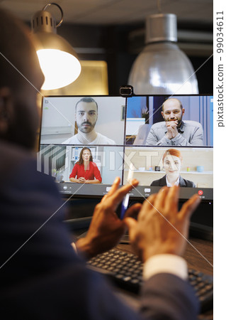 Advisor agent explaining financial strategy to remote team during online videocall meeting, discussing company profit growth report. Diverse business people working overhours at marketing project 99034611