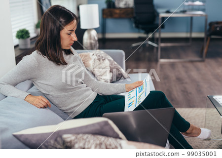 Businesswoman holding papers analyzing, preparing report work results. Businesswoman holding papers analyzing, preparing report work results. 99035001