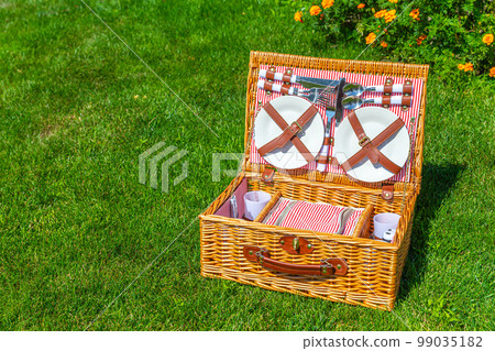 Picnic basket with copy space on green sunny lawn in the park 99035182
