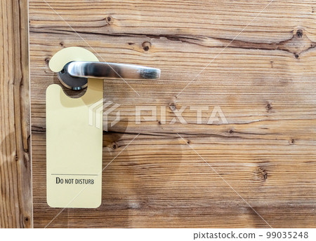 Do not disturb sign hanging on closed door in a hotel Do not disturb sign hanging on closed door in a hotel 99035248