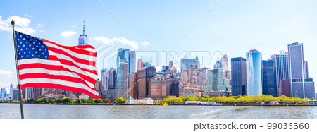 Skyline panorama of downtown Financial District and the Lower Manhattan in New York City with american flag, USA 99035360