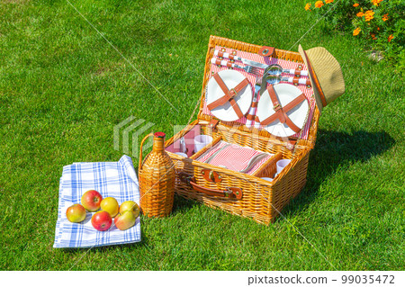 Picnic basket on green sunny lawn in the park 99035472