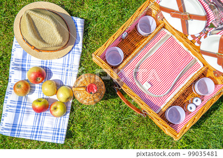 Picnic concept with basket on green sunny lawn in the park 99035481