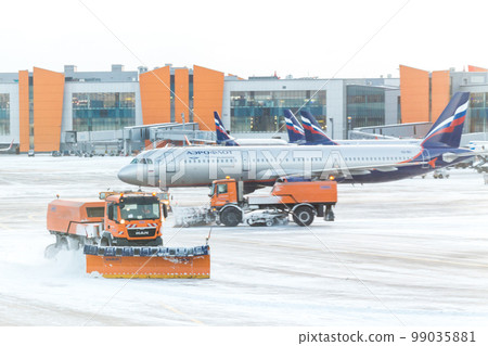 MOSCOW, RUSSIA - DECEMBER 06, 2016 : Snowplow removing snow from runways and roads in airport during snow storm in SHEREMETYEVO airport on December 06.2016 in Moscow. MOSCOW, RUSSIA - DECEMBER 06, 2016 : Snowplow removing snow from runways and roads in airport during snow storm in SHEREMETYEVO airport on December 06.2016 in Moscow. 99035881