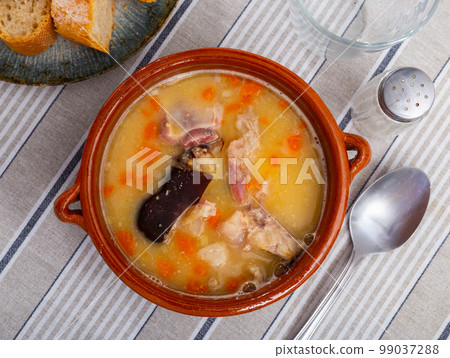 Beautiful serving of pea soup with smoked meat with some bread on side Beautiful serving of pea soup with smoked meat with some bread on side 99037288