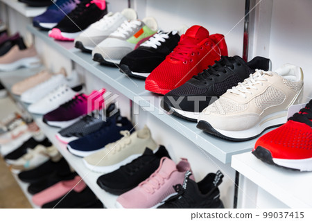 Shelves with training shoes in shoe store 99037415