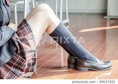 A close-up of the legs of a female student sitting directly on the classroom floor. image, background material 99037892