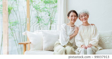 Parent and child relaxing in the living room 99037913