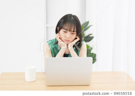A young woman who is worried while looking at a computer 99038558