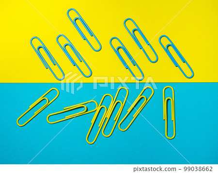 Colored paper clips on paper. Office supplies. Colorful office supplies. Colored paper clips on paper. Office supplies. Colorful office supplies. 99038662