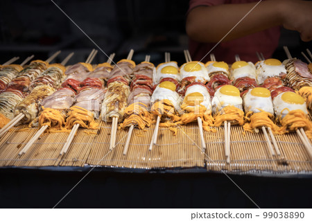 Street food , Japanese Pizza or Okonomiyaki roll on top egg ,cheese and bacan with chopsticks ready to eat. Street food , Japanese Pizza or Okonomiyaki roll on top egg ,cheese and bacan with chopsticks ready to eat. 99038890