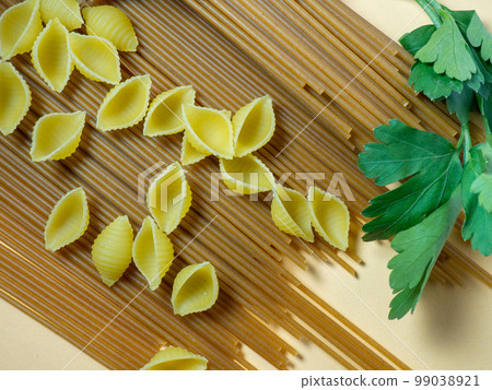 Spaghetti of two types on the table. shells and buckwheat pasta. Italian food. Long pasta. Cooking food. 99038921