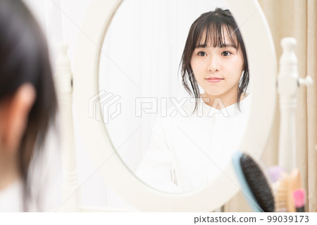 看著梳妝鏡裡的臉的年輕女人 看著梳妝鏡裡的臉的年輕女人 99039173