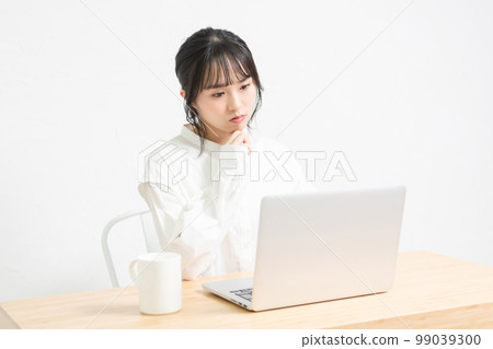 A woman who is worried while using a laptop 99039300