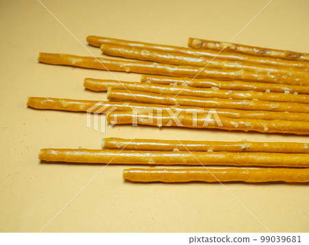 Salted sticks. Confectionery on the table. Salty baked goods. Snack for beer. Dough product on a beige background. 99039681