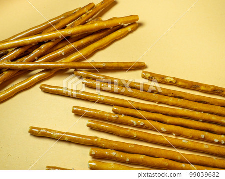 Salted sticks. Confectionery on the table. Salty baked goods. Snack for beer. Dough product on a beige background. Salted sticks. Confectionery on the table. Salty baked goods. Snack for beer. Dough product on a beige background. 99039682