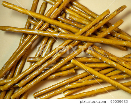 Salted sticks. Confectionery on the table. Salty baked goods. Snack for beer. Dough product on a beige background. Salted sticks. Confectionery on the table. Salty baked goods. Snack for beer. Dough product on a beige background. 99039683