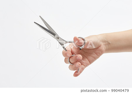 hand with hairdressing scissors hand with hairdressing scissors 99040479