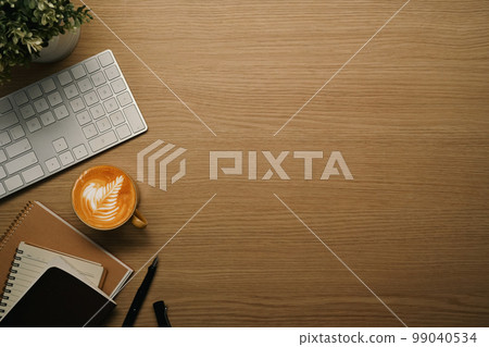 Cup of coffee, books and wireless keyboard on wooden table. Flat lay, top view with copy space Cup of coffee, books and wireless keyboard on wooden table. Flat lay, top view with copy space 99040534