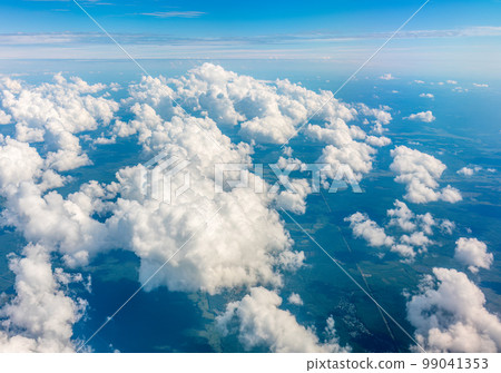 Aerial view from airplane window above green ground. View from the airplane window with beautiful clouds at sunrise Aerial view from airplane window above green ground. View from the airplane window with beautiful clouds at sunrise 99041353