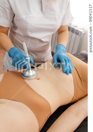 Beautician makes abdominal and waist massage to young woman. Beautician makes abdominal and waist massage to young woman. 99041517