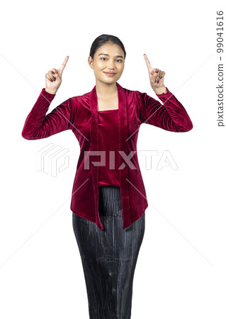 Asian girl wearing red kebaya traditional clothes pointing at something Asian girl wearing red kebaya traditional clothes pointing at something 99041616