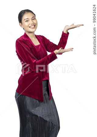 Asian girl wearing red kebaya traditional clothes with open palm hand showing something Asian girl wearing red kebaya traditional clothes with open palm hand showing something 99041624