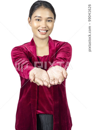 Asian girl wearing red kebaya traditional clothes with open palm hand showing something Asian girl wearing red kebaya traditional clothes with open palm hand showing something 99041626