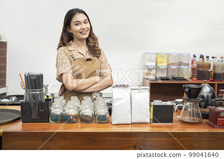 Asian woman baristas standing behind the counter Asian woman baristas standing behind the counter 99041640