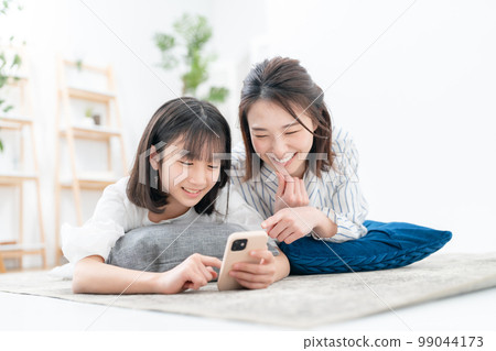 Sprawled parent and child Smartphone 99044173