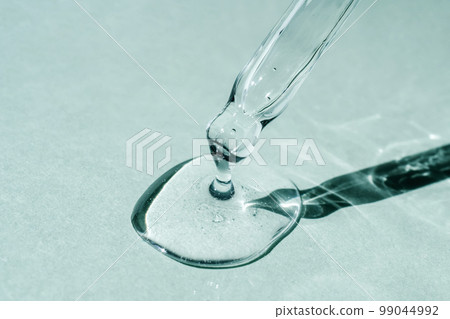 A drop of cosmetic oil falls from the pipette A drop of cosmetic oil falls from the pipette 99044992