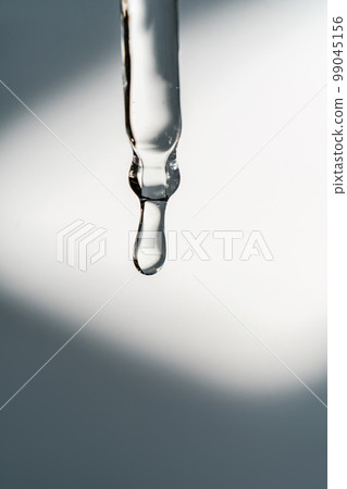 A drop of cosmetic oil falls from the pipette 99045156