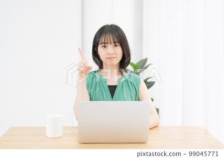 Young woman showing points while using a computer Young woman showing points while using a computer 99045771