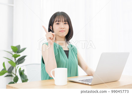 Young woman showing points while using a computer 99045773