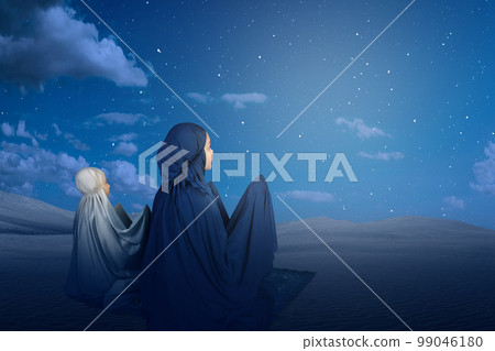 Asian Muslim mother and daughter in a hijab raised hands and praying together Asian Muslim mother and daughter in a hijab raised hands and praying together 99046180