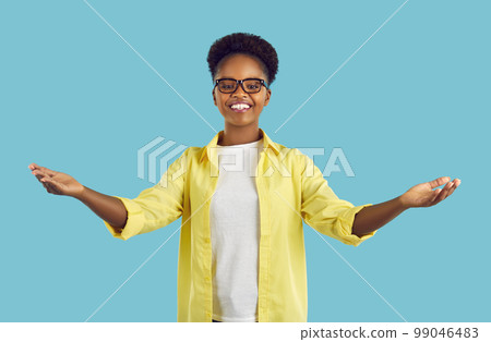 Happy cheerful afroamerican woman with ponytail hair spreading arms wide on turquoise background. 99046483
