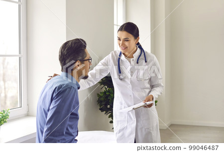Professional female doctor approvingly, carefully puts her hand on the shoulder of young male patient. Professional female doctor approvingly, carefully puts her hand on the shoulder of young male patient. 99046487