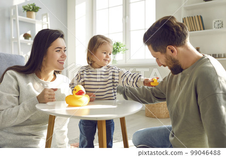 Little girl is having fun at home playing with toys with her loving mom and dad. Little girl is having fun at home playing with toys with her loving mom and dad. 99046488