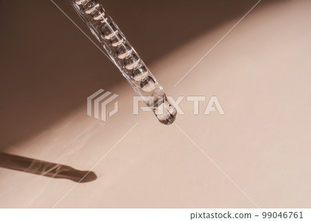 A drop of cosmetic oil falls from the pipette A drop of cosmetic oil falls from the pipette 99046761