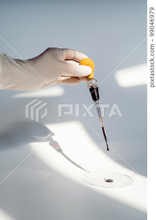 The hand holds a test tube with blood. 99046979