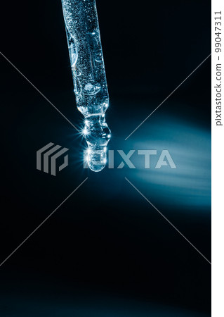 A drop of cosmetic oil falls from the pipette 99047311