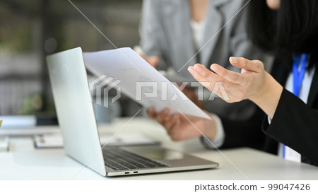 Professional Asian female boss working with her assistant in the office, reviewing business report Professional Asian female boss working with her assistant in the office, reviewing business report 99047426