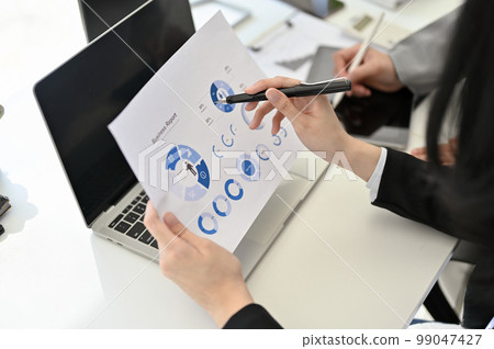 Professional Asian businesswoman examining financial report, planning project with her assistant Professional Asian businesswoman examining financial report, planning project with her assistant 99047427