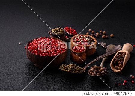 Composition, concept, consisting of several types of different colors of allspice in bowls and spoons 99047679