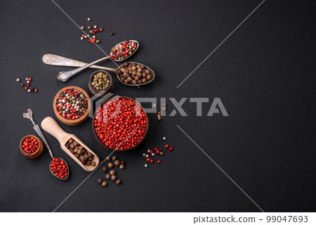 Composition, concept, consisting of several types of different colors of allspice in bowls and spoons 99047693