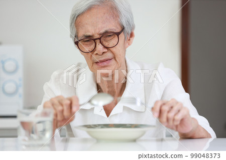 Disappointed old people looking at food on dish,eating leftovers,monotonous overnight food,tired expression feel bad,disgusted,Asian senior woman having lack of appetite,diet, nutrition of elderly Disappointed old people looking at food on dish,eating leftovers,monotonous overnight food,tired expression feel bad,disgusted,Asian senior woman having lack of appetite,diet, nutrition of elderly 99048373