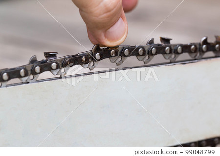 Correct chain tension using the special tool on the chainsaw bar. Chain tension adjustment. 99048799