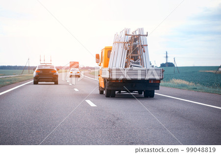 The truck in the company transports pvc windows for their installation. Transportation of pvc windows on the road. Copy space for text 99048819