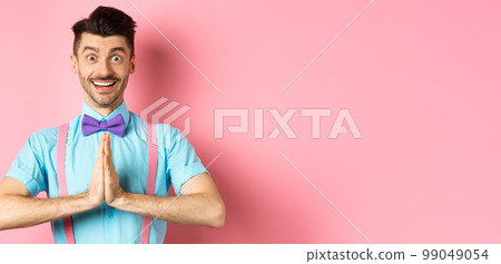 Image of smiling young man asking please, looking grateful at camera, Guy in bow-tie say thank you, standing over pink background Image of smiling young man asking please, looking grateful at camera, Guy in bow-tie say thank you, standing over pink background 99049054