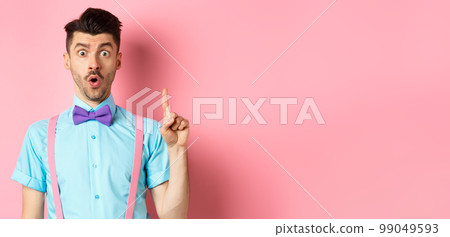 Creative man pitching an idea, saying suggestion with raised finger, standing on pink background 99049593